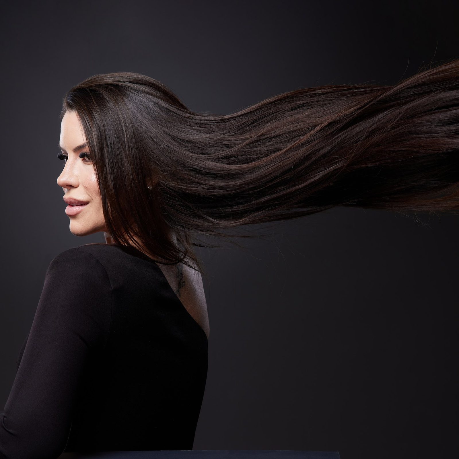 Dra. Ana Carolina Fakri em retrato editorial, cabelo em movimento